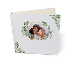 album per matrimonio con foto in cornice geometrica e rami verdi